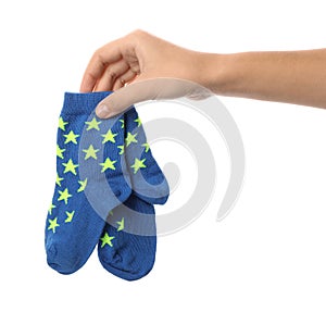 Woman holding pair of cute child socks on white background
