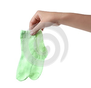 Woman holding pair of cute child socks on white background