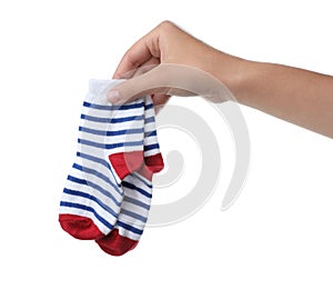 Woman holding pair of cute child socks on white background