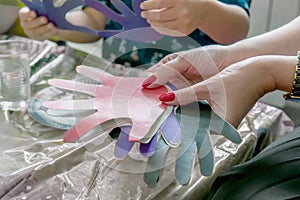 A woman holding a paper-cut small children`s symbols. The teacher is engaged with children. Training