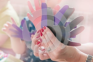 A woman holding a paper-cut small children`s symbols. The teacher is engaged with children. Training. Toned