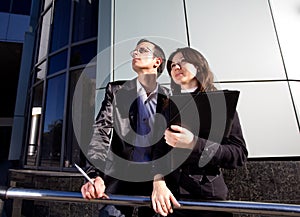 Woman holding papers in hand and points man up