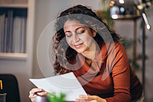 Woman holding papers in her hands, calculating family budget