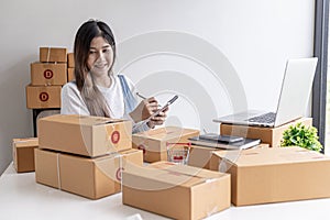 Woman holding parcel boxes to write customer address information before shipping to customers via private transport service.