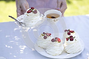 Pavlova cakes with cream and fresh summer berries