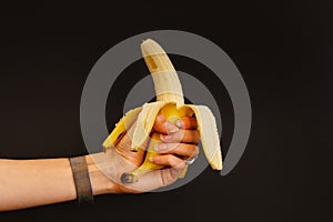 Woman holding peeled banana in her hand.