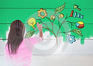 Woman holding pen and Drawing of Business graphics on plant branches on wall