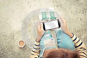 Woman holding phone white screen on top view vintage style