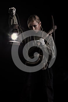 Woman holding pick and oil lamp