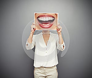 Woman holding picture with big smile photo