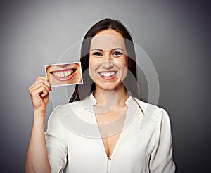Woman holding picture with yellow teeth