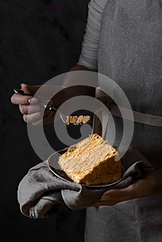Woman holding a piece traditional napoleon cake