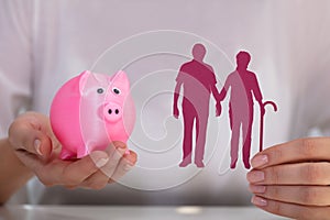 Woman Holding Piggy Bank And Cutout Figure