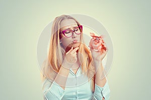 Woman holding piggy thinking cute