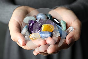 Woman holding pile of different gemstones