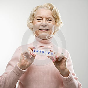 Woman holding pill box.