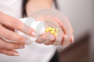 Woman holding pill in hand.