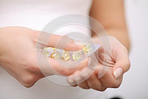 Woman holding pill in hand.