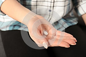 Woman holding pill in hand