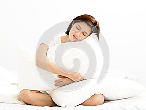 woman holding a pillow in bed room