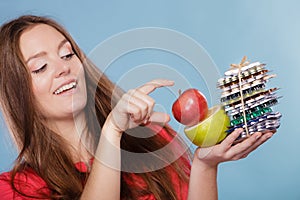 Woman holding pills and fruits. Health care