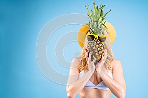 Woman is holding pineapple in glasses