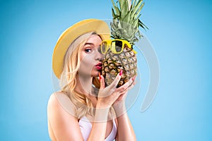 Woman is holding pineapple in glasses