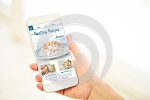Woman holding a pink gold blank smartphone healthy recipes blog