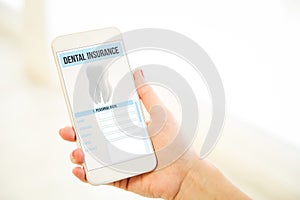 Woman holding a pink gold blank smartphone showing dental insurance
