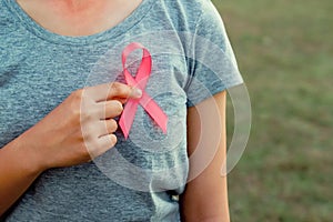 woman holding pink ribbon breast cancer awareness
