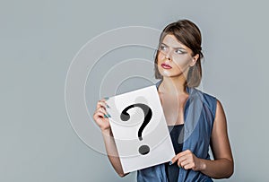 Woman holding a placard with question mark symbol, thinking. Girl question. Woman with doubtful expression and question