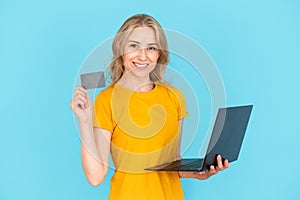 Woman holding plastic card and laptop computer, making online payment