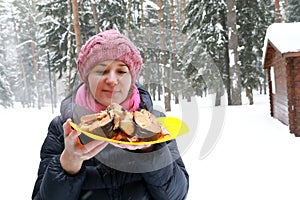 Woman holding plate of grilled Coho Salmon Fillets