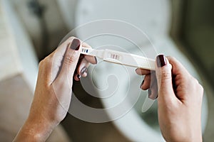 Woman holding a positive pregnancy test photo