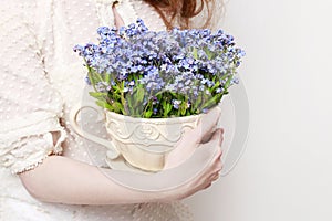 Woman holding a pot with forget-me-not flowers