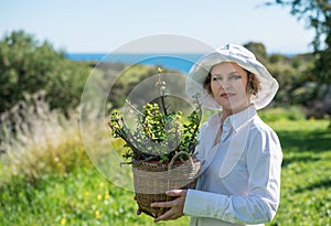 Woman holding a pot with plant