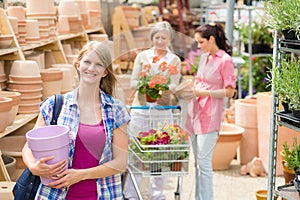 Woman holding purple pot in garden center