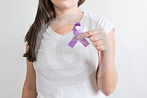 Woman holding a purple ribbon of the International Day for the Elimination of Violence Against Women