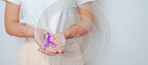 Woman holding purple Ribbon for Violence, Pancreatic, Esophageal, Testicular cancer, Alzheimer, epilepsy, lupus, Sarcoidosis and