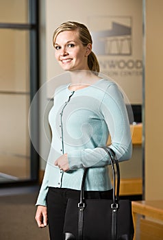 Woman holding purse in office lobby