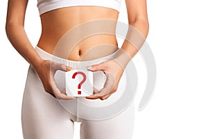 Woman holding question mark over her abdomen