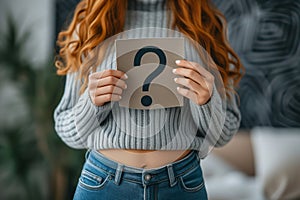 Woman holding question mark over her abdomen