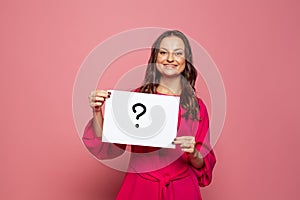 Woman holding question mark sign on pink background