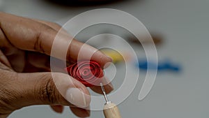 Woman holding a quilled paper roll in her hand. Close-up.