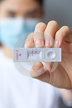 Woman holding Rapid Antigen Test kit with Negative result during swab COVID-19 testing. Coronavirus Self nasal or Home test,