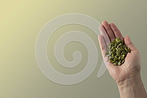 Woman holding raw unshelled pumpkin seeds, closeup view, isolated. Healthy, vegetarian super food or snack. Template for design