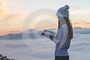 Woman holding reading Bible on Mountain in the Morning- Image