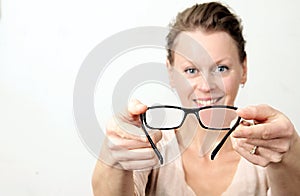 Woman holding reading glasses ready to be used