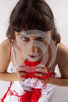 Woman holding red ball of wool looking in camera