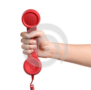 Woman holding red corded telephone handset on white background, closeup. Hotline concept